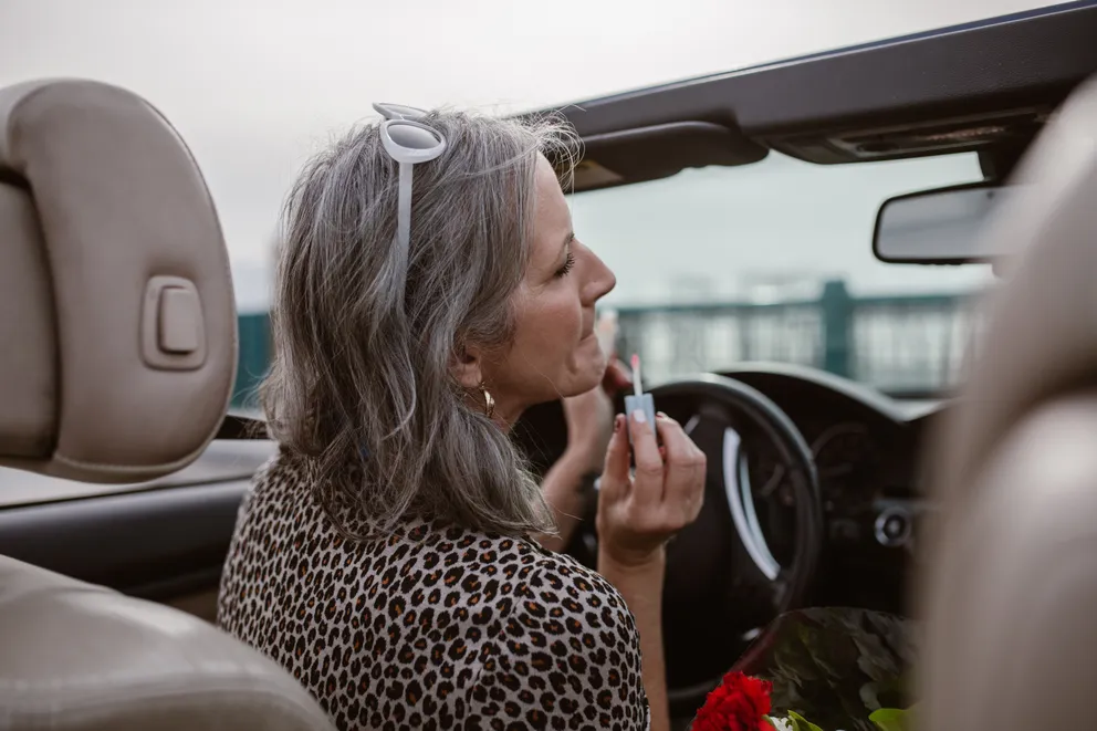 Mujer en un vehículo maquillándose. | Foto: Pexels