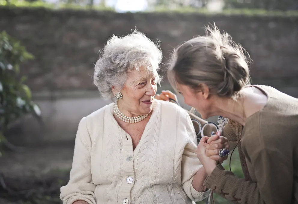 Una mujer conversando amenamente con una anciana. | Foto: Pexels 