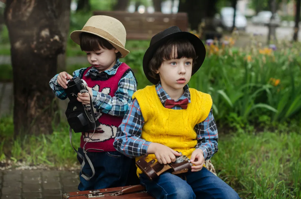 Dos niños con una maleta en un parque. | Foto: Pexels