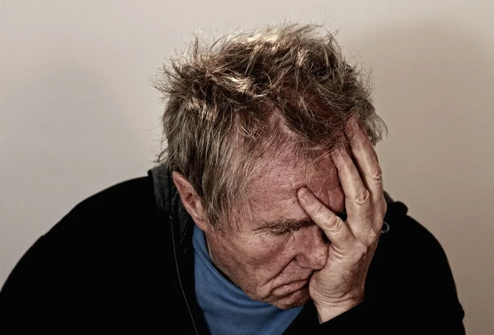 Hombre triste con la mano en el rostro. │Foto: Pixabay