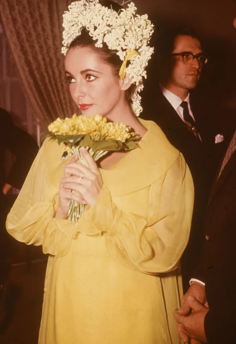 Elizabeth Taylor tient un bouquet de fleurs lors de son mariage avec l'acteur Richard Burton le 15 mars 1964.| Photo : Hulton Archive/Getty Images