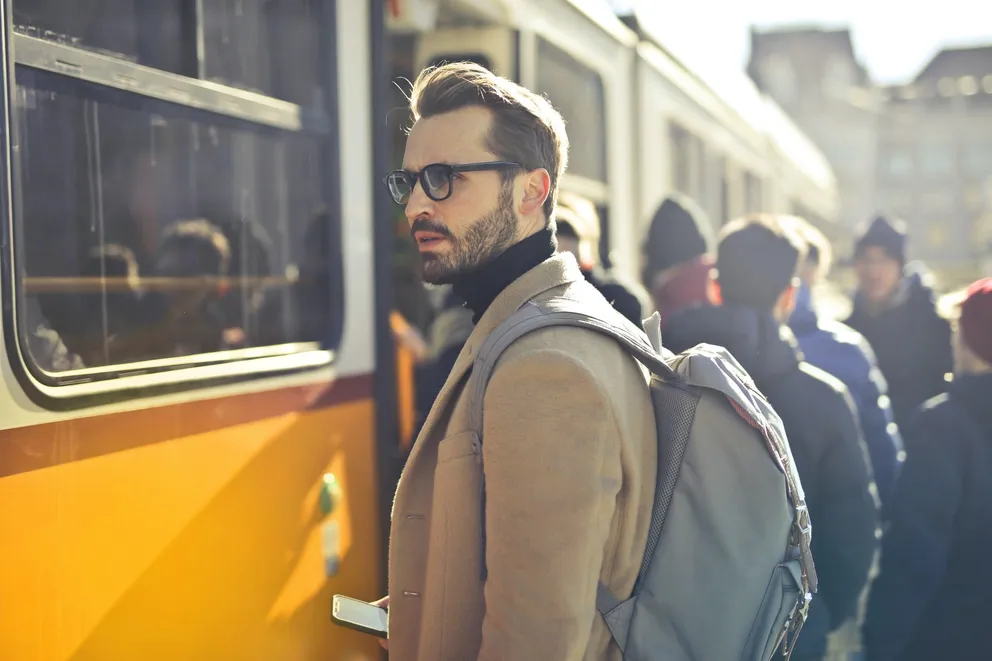 Un hombre con un bolso en su espalda a punto de abordar un tren. | Foto: Unsplash