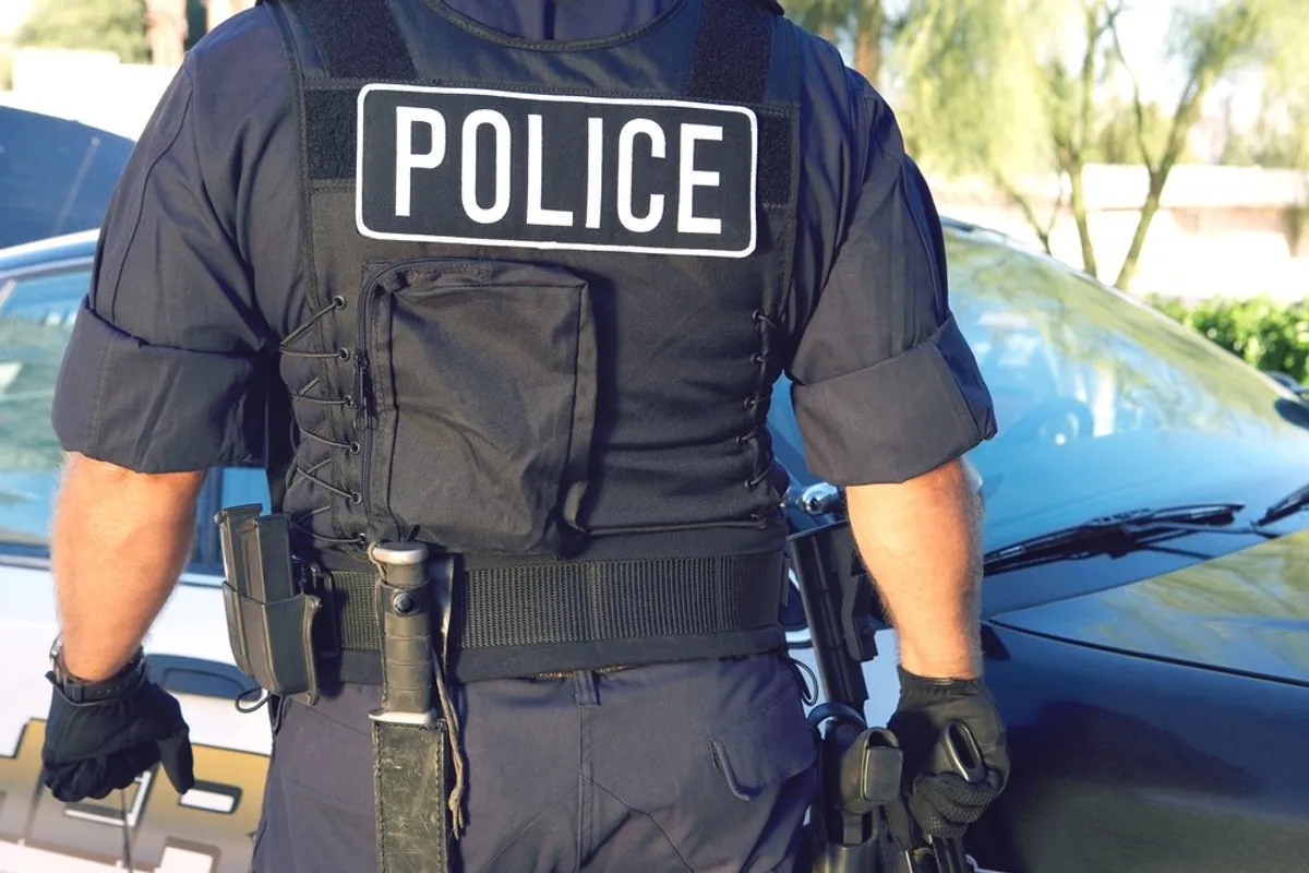 A policeman standing by a car. | Photo: Shutterstock
