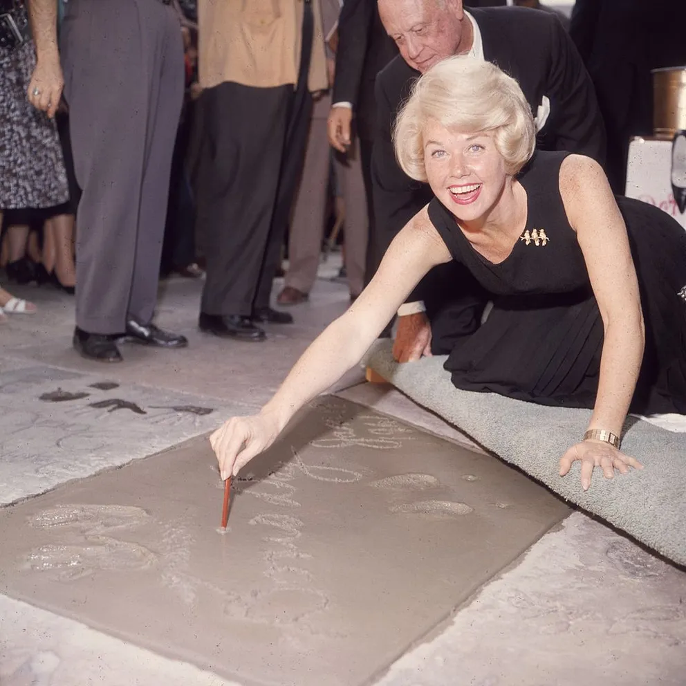 Doris Day signant son nom dans du ciment sur Hollywood Boulevard, à Hollywood, le 19 janvier 1961 | Photo : Getty Images