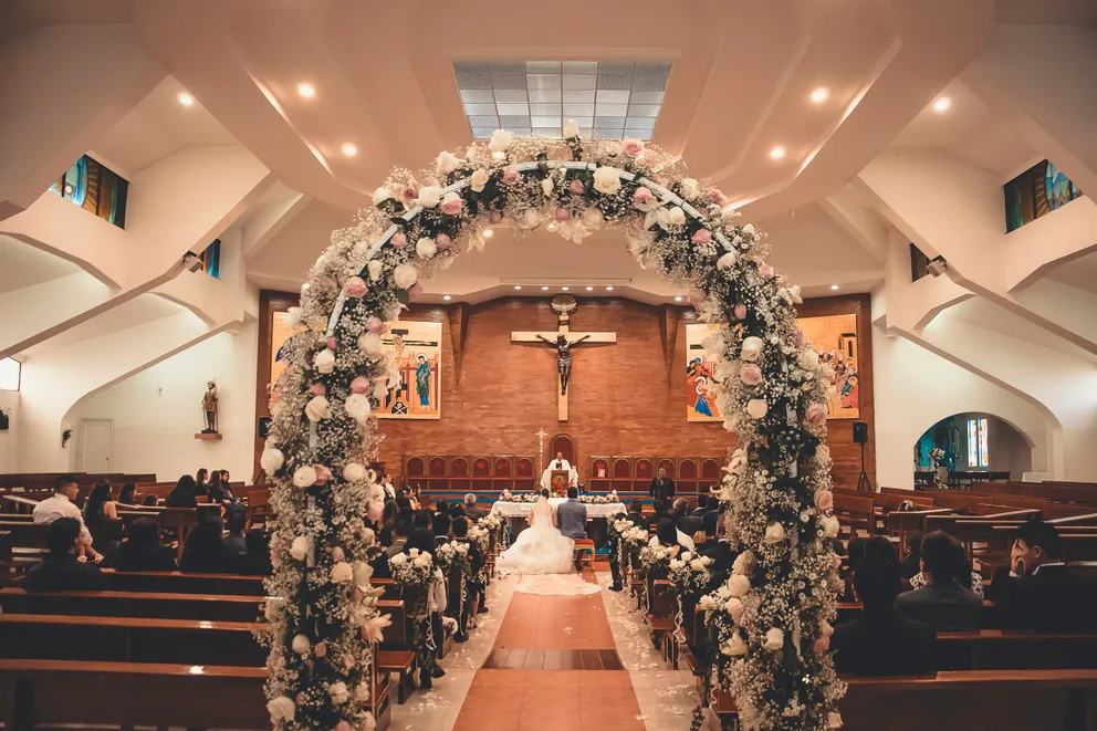 Novios en compañía de sus invitados durante su boda en una iglesia. | Foto: Pexels