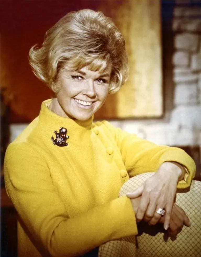 Doris Day, American actress and singer, smiling and wearing a yellow high-necked jacket, with a brooch on her right shoulder, in a studio portrait, around 1965. |  Photo: Getty Images