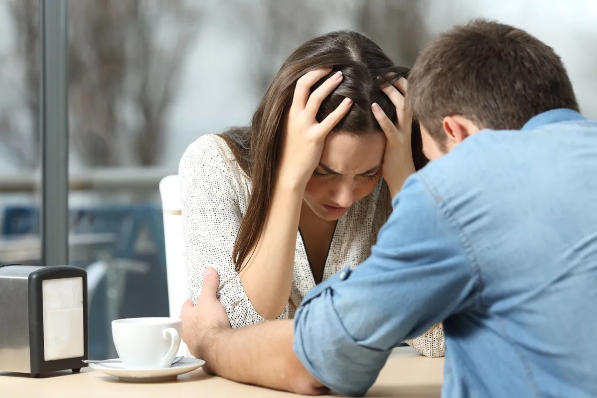 Pareja preocupada sentada a la mesa. | Foto: Shutterstock