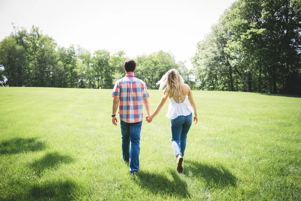 Una pareja tomada de la mano caminando en un parque. | Foto: Unsplash
