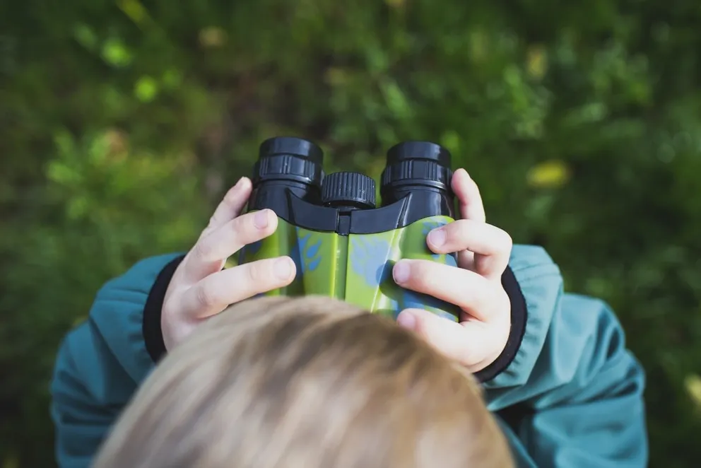Niño observando el horizonte con unos binoculares. | Foto: Unsplash