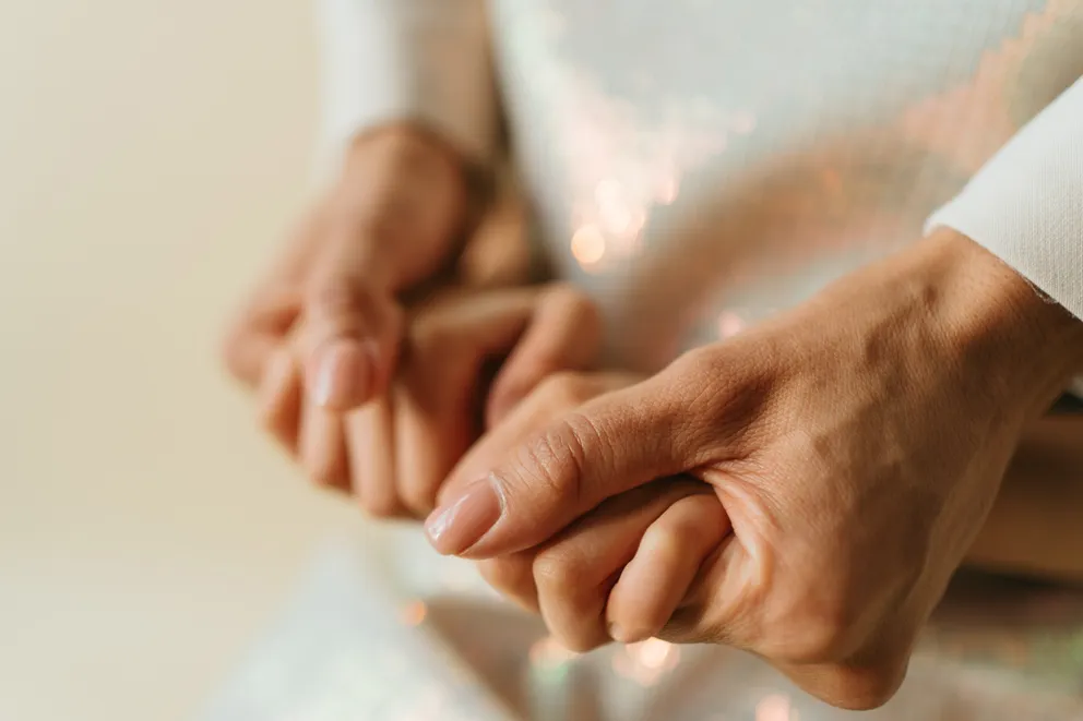 Mujer sosteniendo las manos de su hija con fuerza. | Foto: Pexels