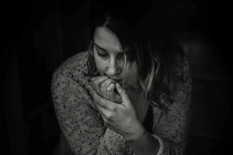 Una mujer con rostro preocupado y su mano sobre su boca. | Foto: Pexels