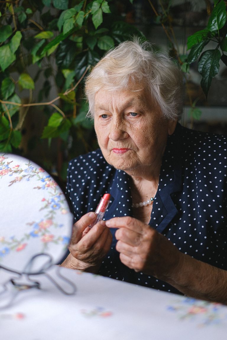 Una mujer mayor maquillándose. | Foto: Pexels 