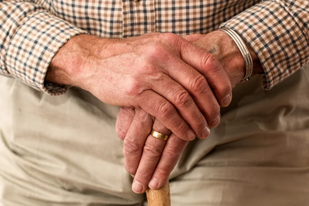 Anciano sosteniendo un bastón. | Foto: Pexels