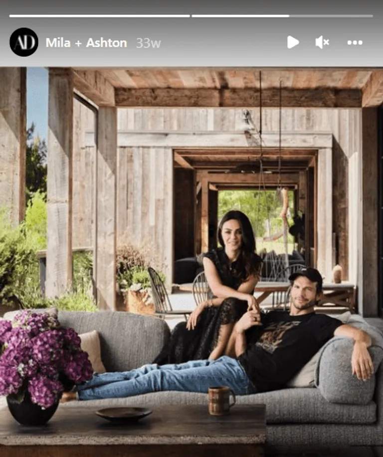 Le couple Mila Kunis et Ashton Kutcher assis sur un canapé dans leur maison de Los Angeles. | Photo : Instagram/archdigest