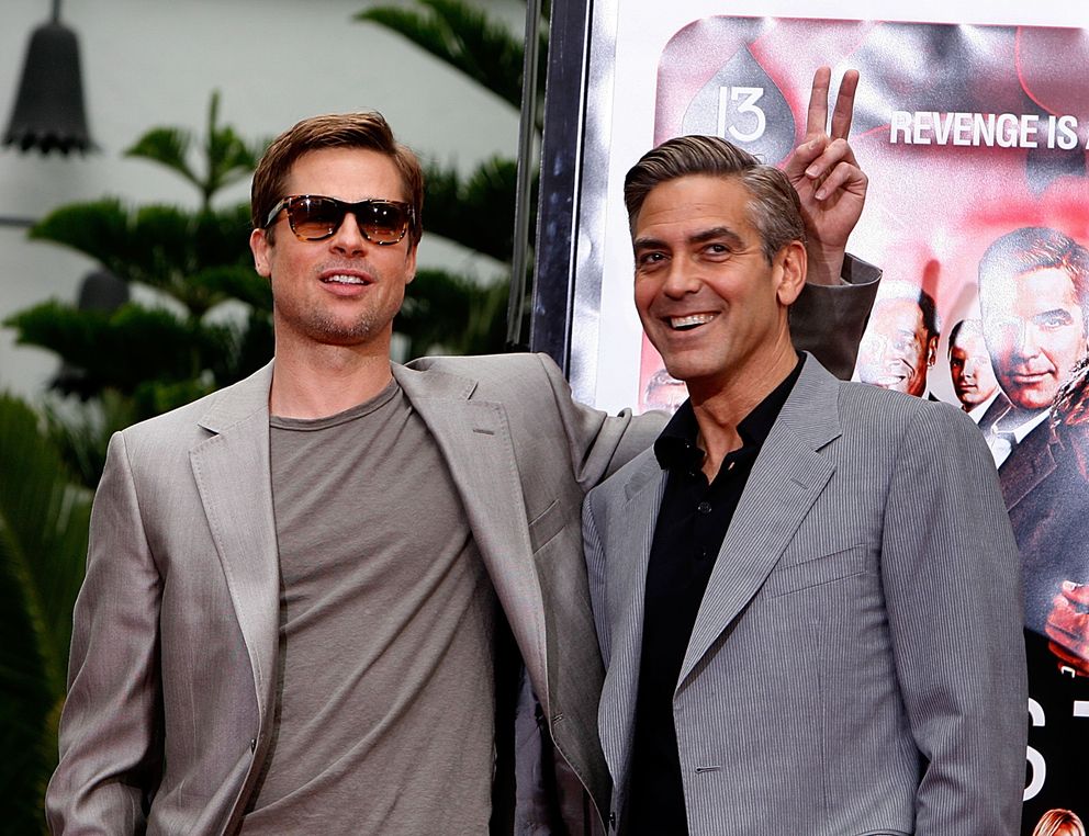 Brad Pitt et George Clooney posent pour des photos lors de leur cérémonie d'empreintes de mains et de pieds au Grauman's Chinese Theatre le 5 juin 2007 à Hollywood, Californie | Source : Getty Images