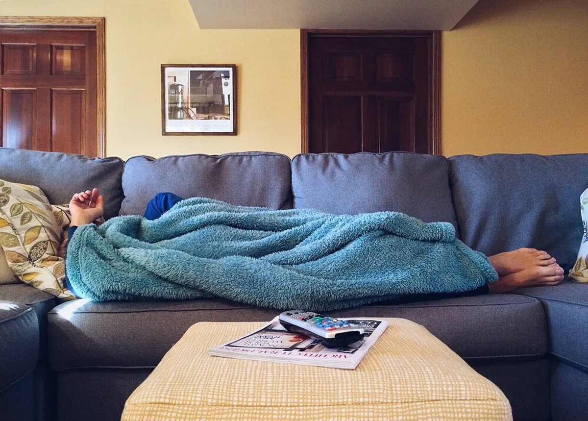Un homme qui dort sur un canapé. | Image : Pixabay.