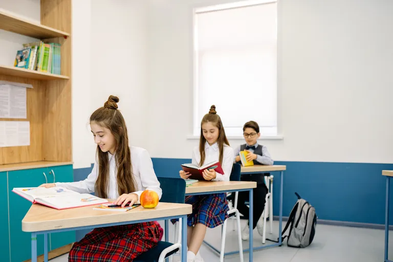 Niños sentados en sus escritorios en un salón de clases. | Foto: Pexels