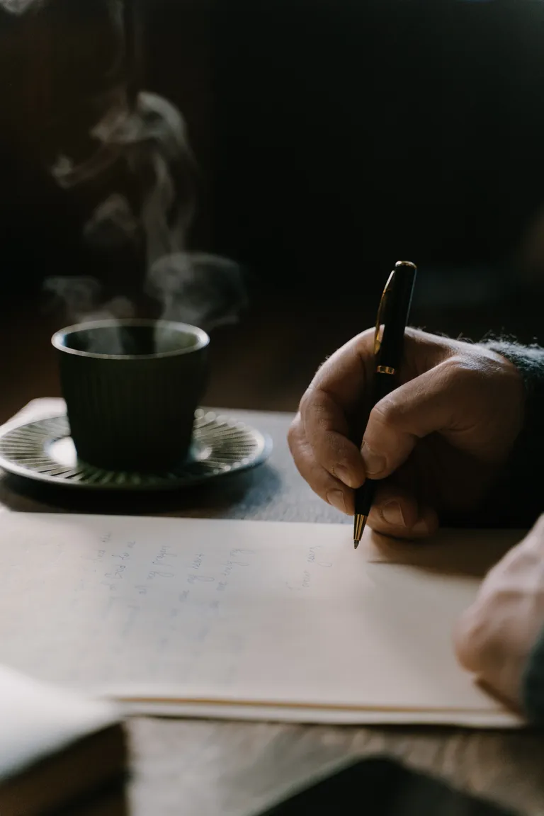 Un hombre escribiendo sobre unos papeles. | Foto: Pexels