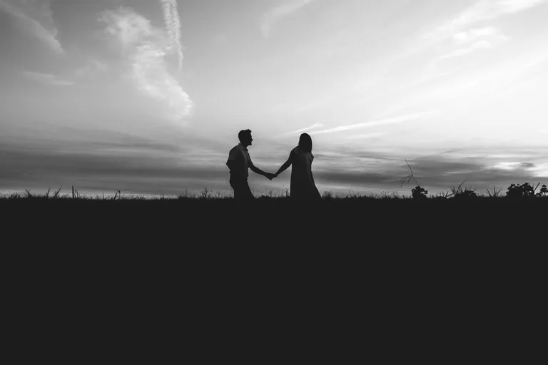 Una pareja tomada de la mano en un campo. | Foto: Pexels
