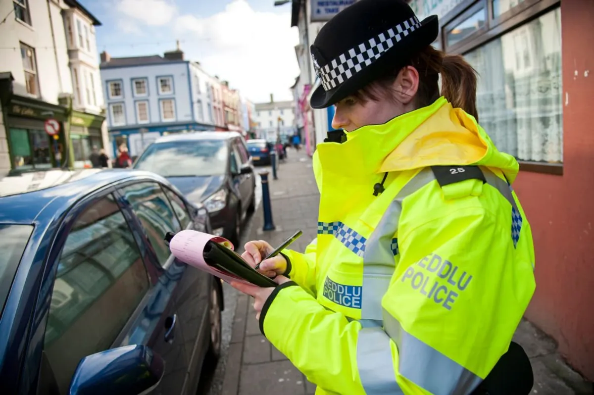 Dyfed-Powys police officer issuing a parking ticket | Photo: Getty Image