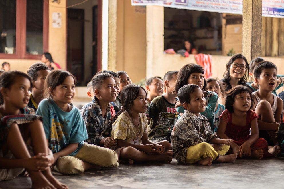 Un grupo de niños sentados en el suelo. | Foto: Unsplash