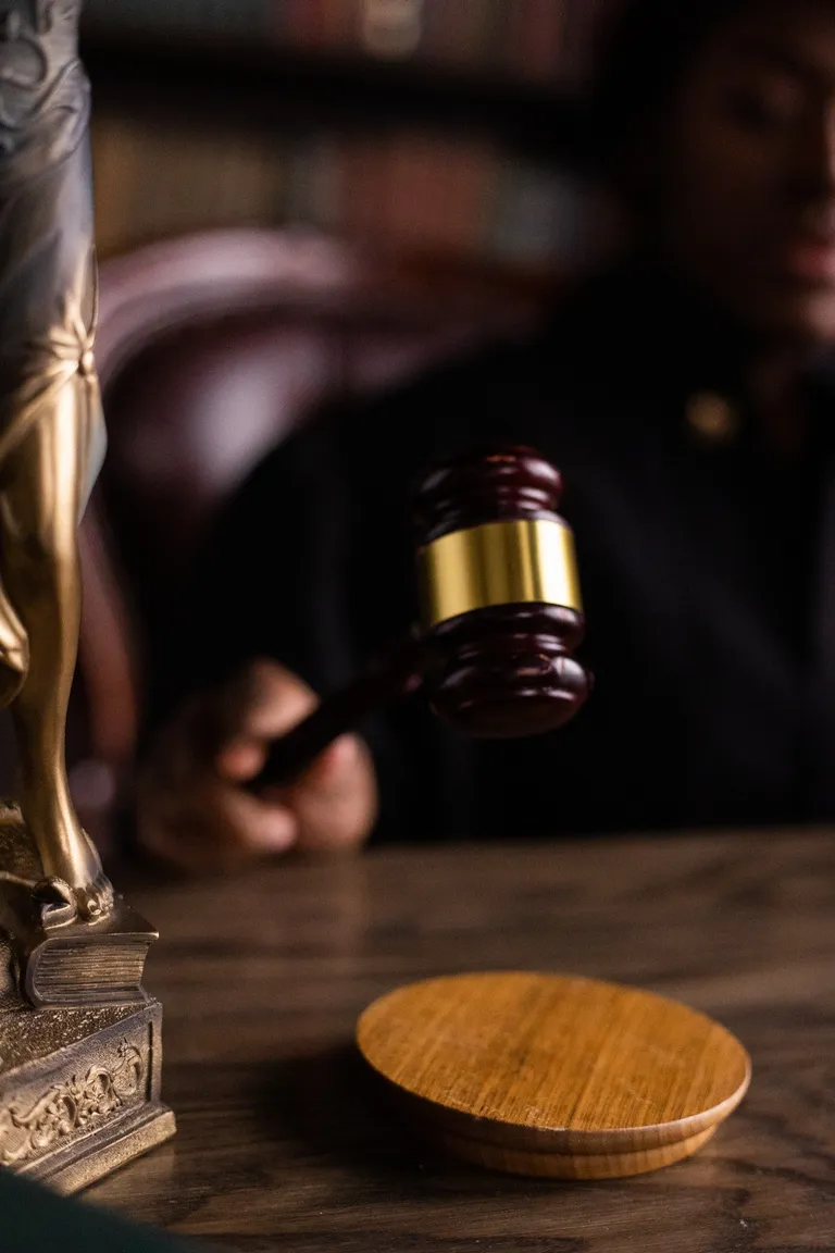 Un juez sosteniendo un mazo frente a un estrado. | Foto: Pexels