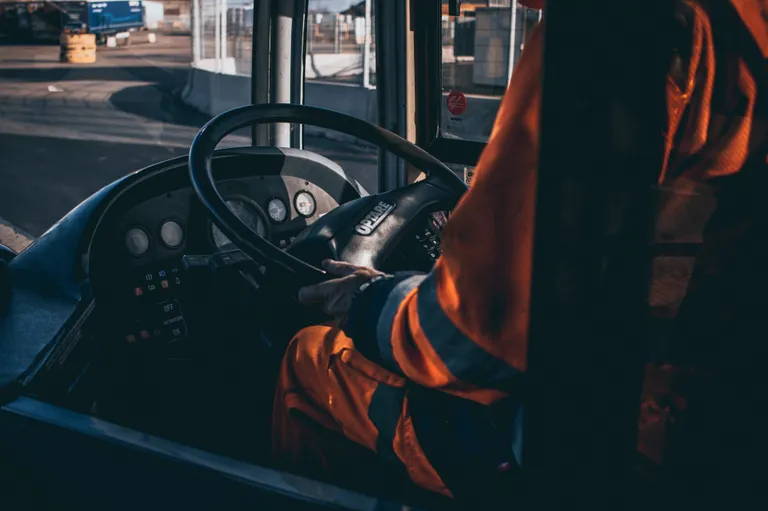 Conductor de autobús sosteniendo el volante de su vehículo. | Foto: Unsplash