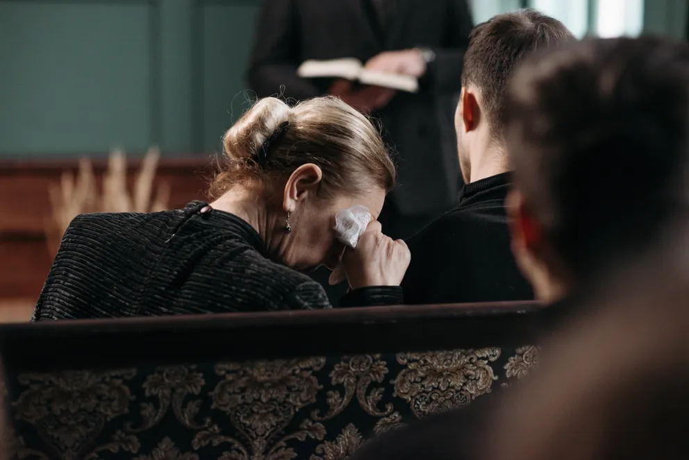Una mujer vestida de negro llorando en un funeral. | Foto: Pexels