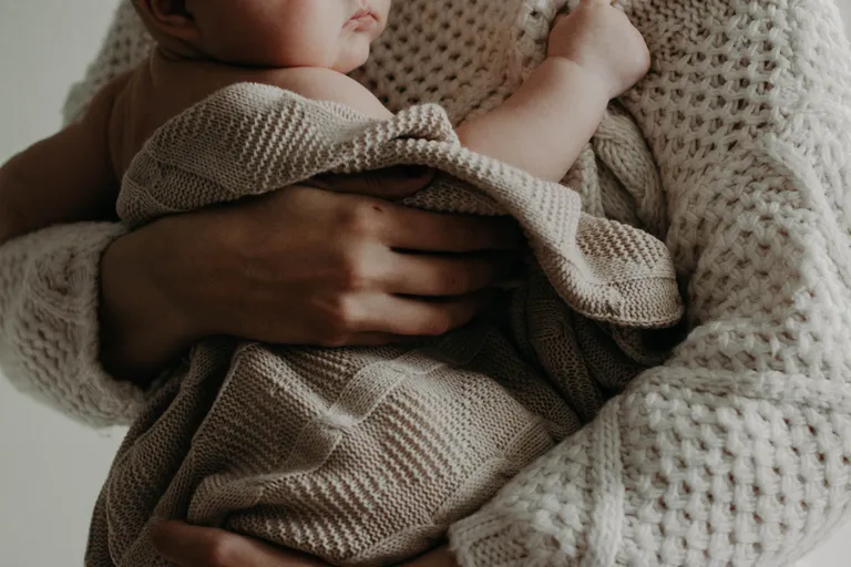 Una mujer sosteniendo a un bebé en brazos. | Foto: Pexels