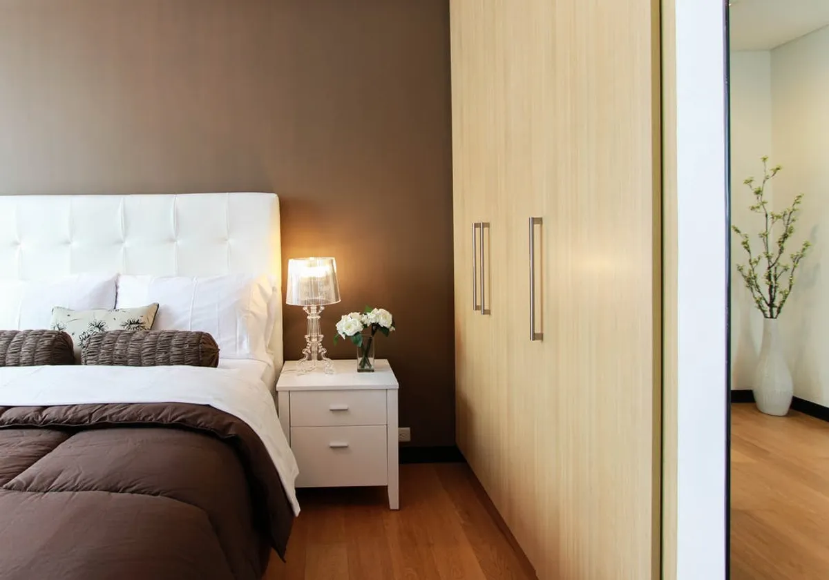An up-close photo of a closed closet and a bedside. | Photo: Pexels.