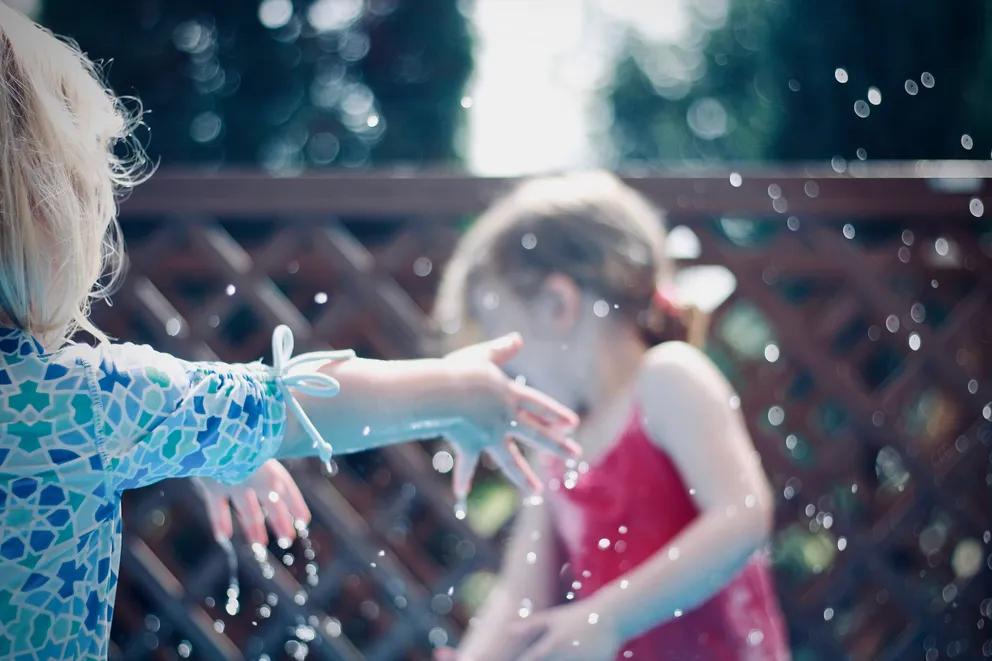 Dos niñas jugando con agua. | Foto: Unsplash