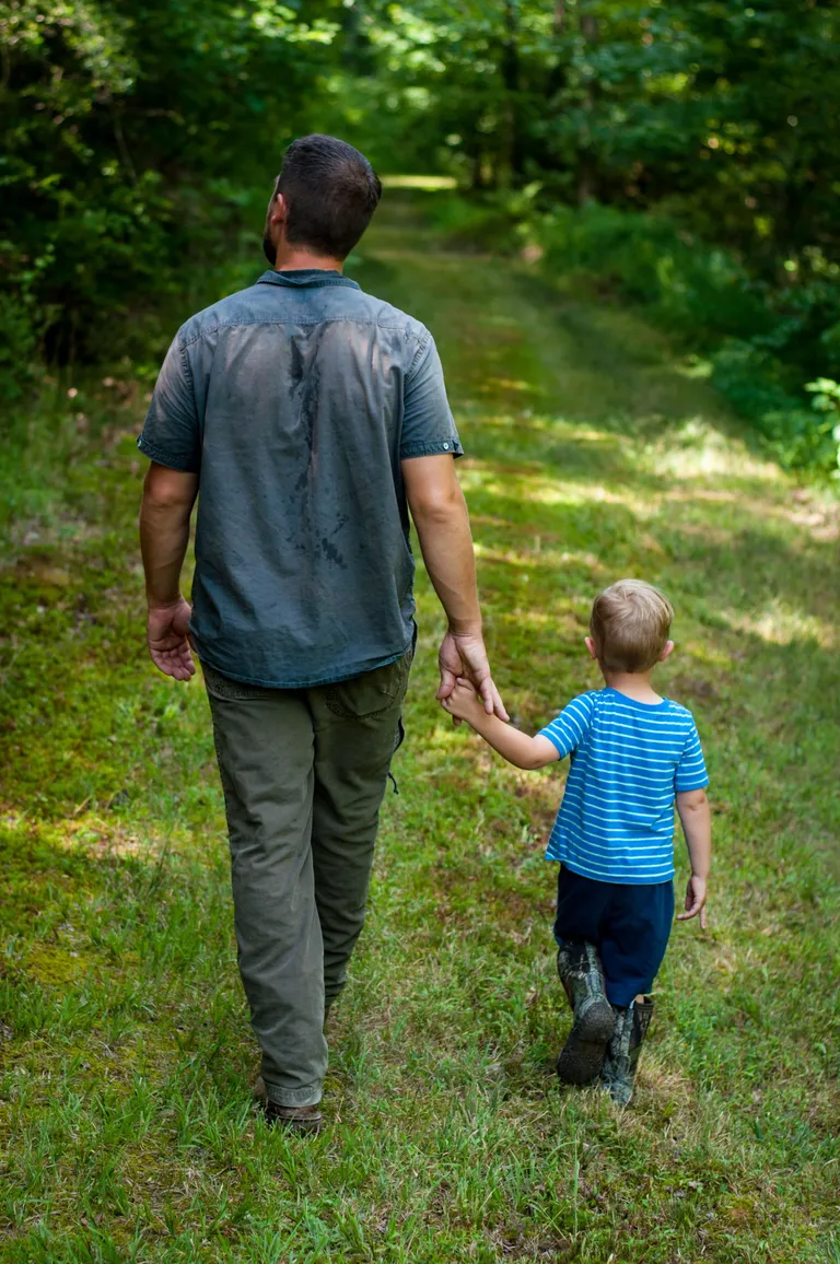 Un hombre junto a un niño caminando a través de la vegetación. | Foto: Unsplash