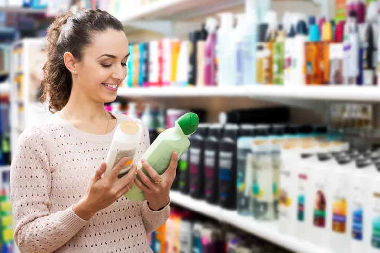Mujer eligiendo productos para el cabello en tienda. | Foto: Shutterstock