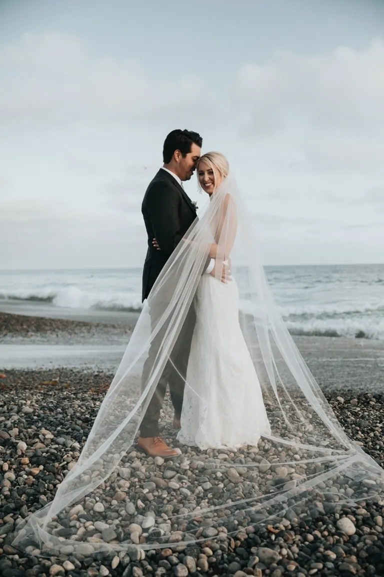 Pareja de recién casados a la orilla de una playa. | Foto: Unsplash