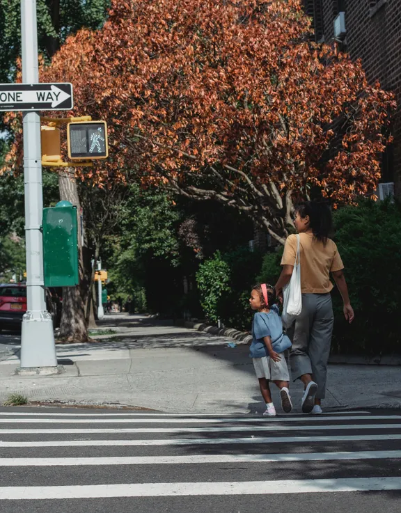 Una mujer y su hija caminando por un paso peatonal. | Foto: Pexels