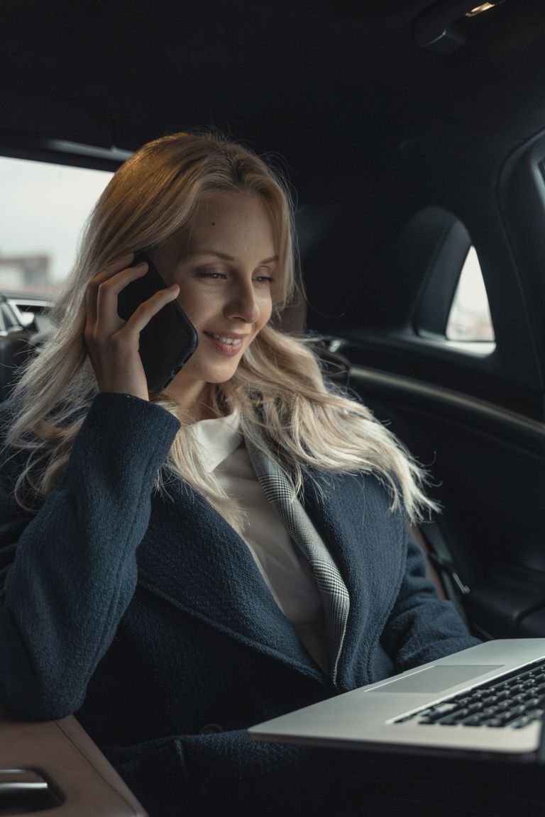 Una mujer de negocios hablando a través de un teléfono celular en su automóvil. | Foto: Pexels