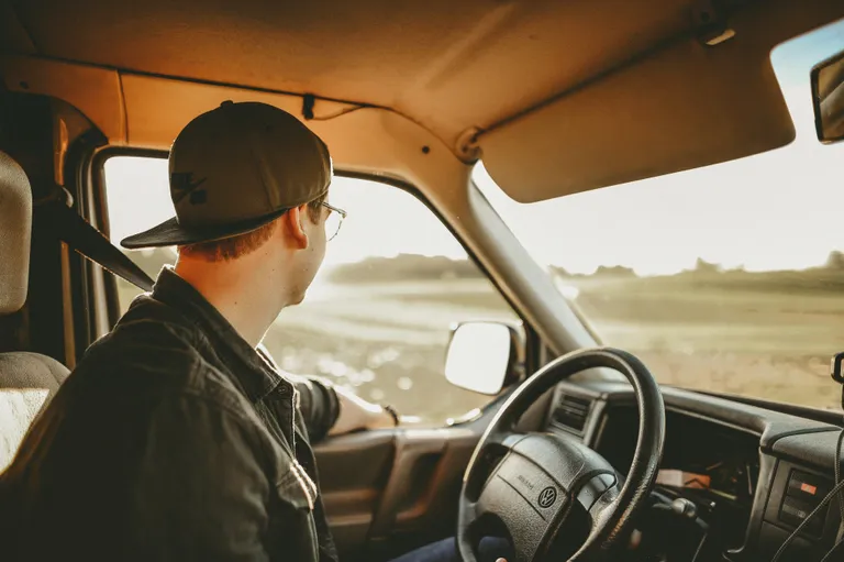 Hombre con una gorra conduciendo un vehículo. | Foto: Pexels