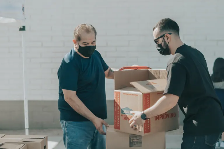 Dos hombres cargando unas cajas. | Foto: Unsplash