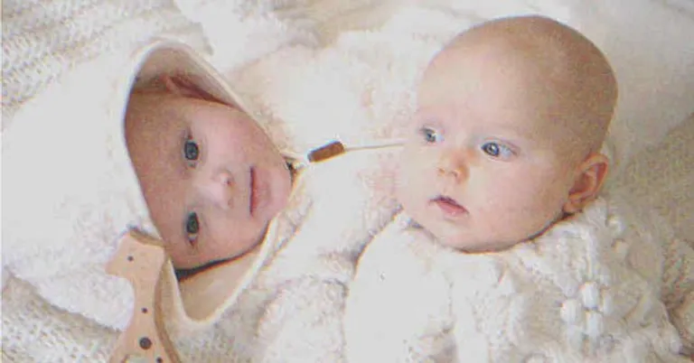 Bebés mellizos recostados en uno del otro. | Foto: Shutterstock