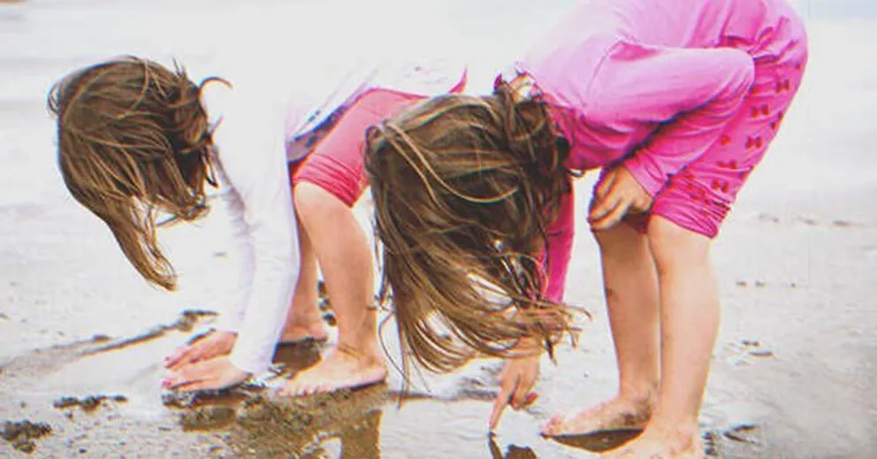 Dos niñas jugando con la arena en la playa. | Foto: Shutterstock