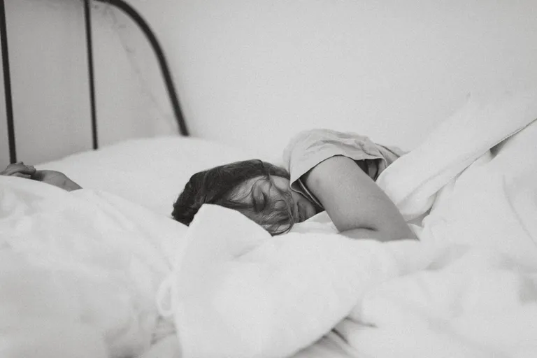 Una mujer durmiendo sobre una cama. | Foto: Unsplash