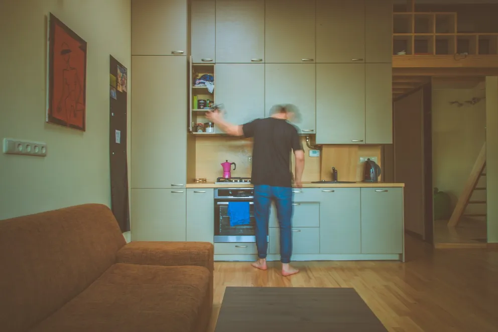 Un hombre revisando el gabinete de su cocina. | Foto: Unsplash