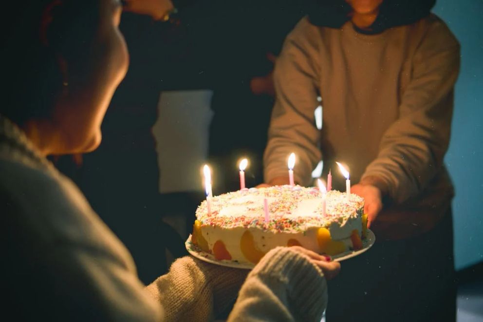 Dos personas sosteniendo un pastel de cumpleaños. | Foto: Pexels