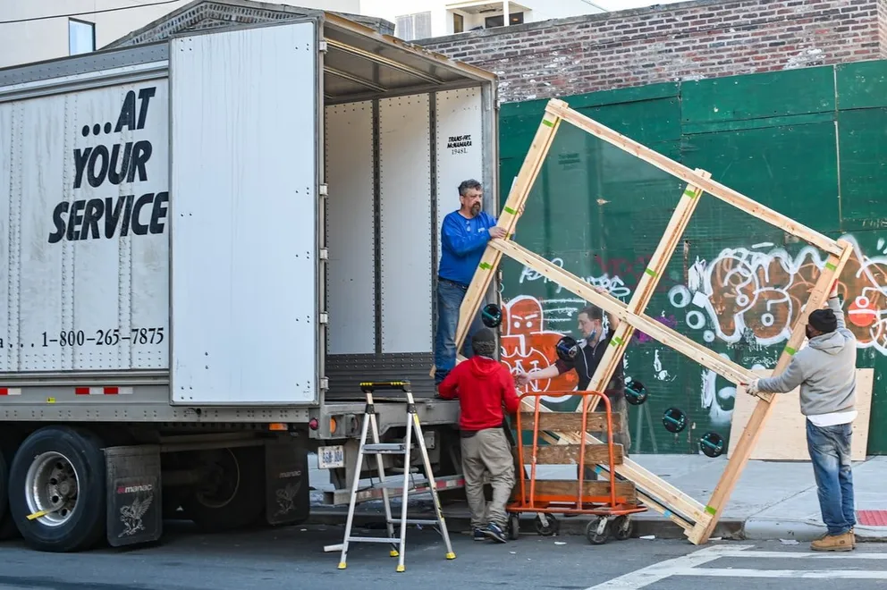 Hombres descargando objetos de un camión de mudanzas. | Foto: Unsplash