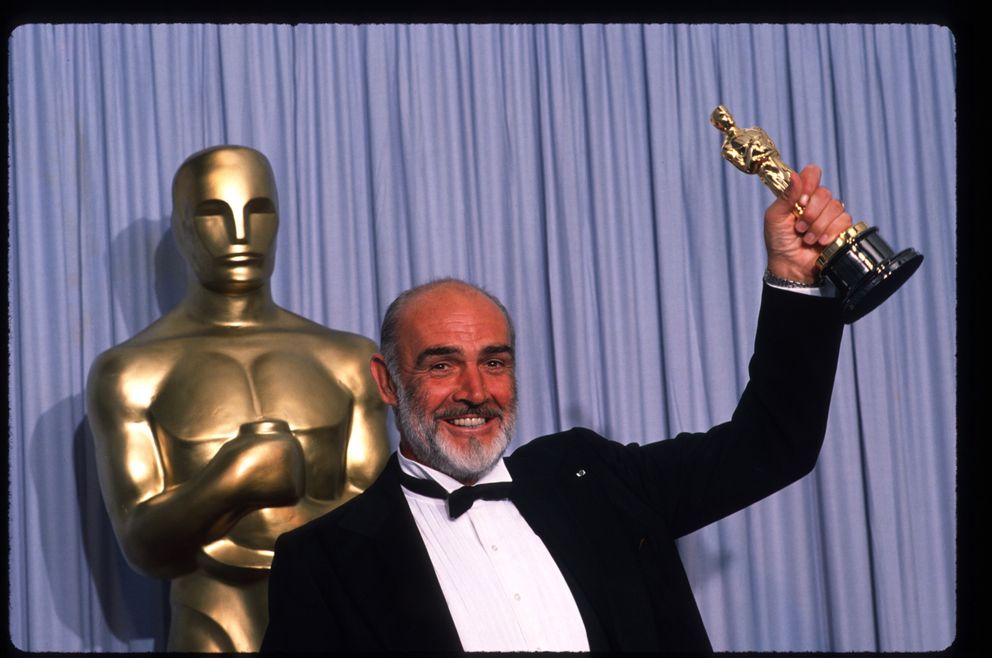 Sean Connery brandit son Oscar du meilleur acteur dans un second rôle pour "Les Incorruptibles" lors de la cérémonie des Oscars le 11 avril 1988 à Los Angeles, CA | Source : Getty Images