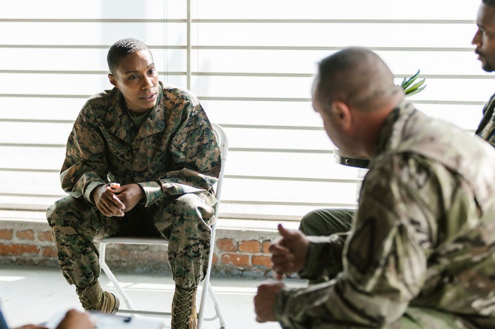 Unos militares sentados conversando. | Foto: Pexels
