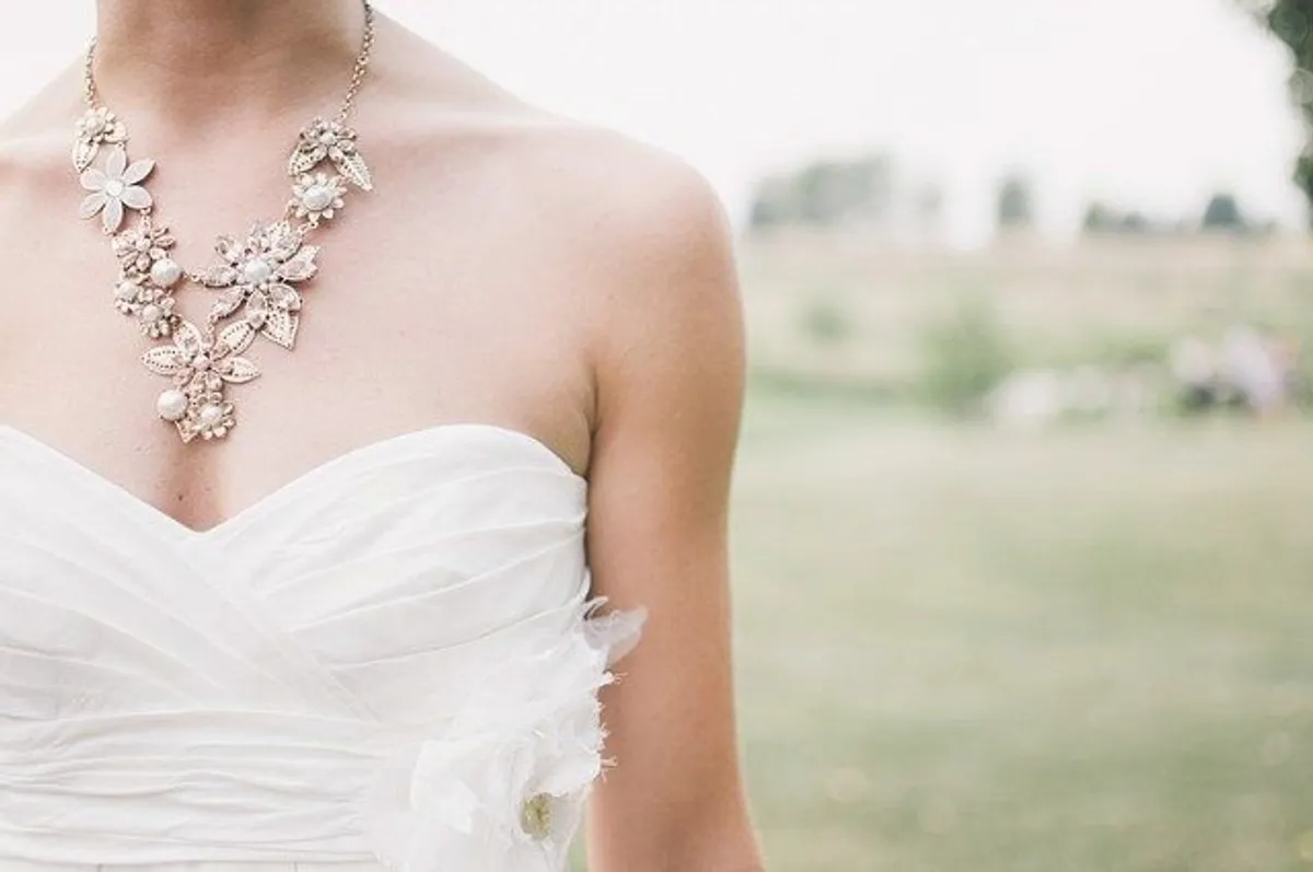 Mujer vistiendo un traje de novia y un collar. | Foto: Pexels