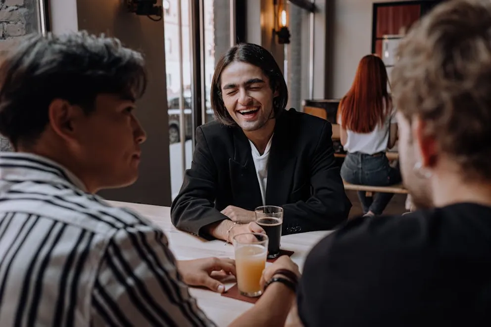 Three male friends enjoying drink at a bar. | Photo: Pexels