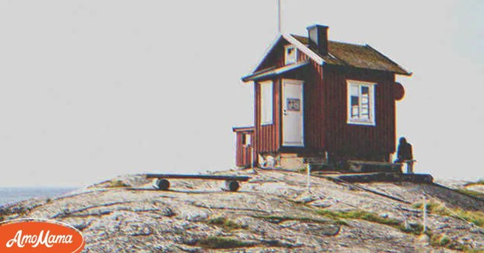Lucy a remarqué un homme assis seul devant une maison d'une chambre sur la côte. | Source : Shutterstock