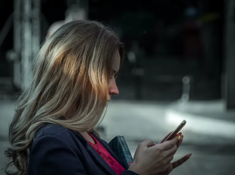Una mujer escribiendo a través de un teléfono celular. | Foto: Pexels